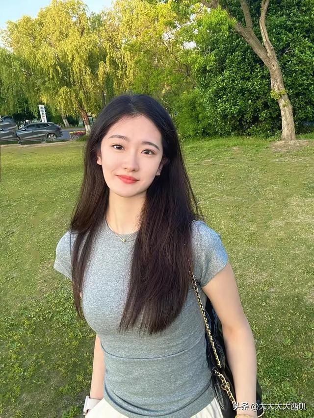 26岁灰色t恤白色裤子白色运动鞋美女，草坪上拍摄写真照