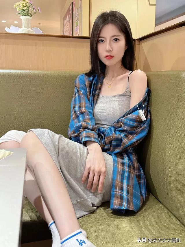 美丽如画！25岁灰色吊带连衣裙美女餐厅沙发上坐着拍摄写真照